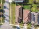 Aerial view of two houses with brown roofs, green lawns, and a street with a car parked on the side at 17596 Terrazzo Way, Land O Lakes, FL 34638