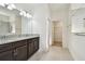 Modern bathroom featuring granite countertops, double sinks, and a tiled floor at 17596 Terrazzo Way, Land O Lakes, FL 34638