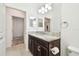 Bathroom features a granite countertop vanity, decorative mirror, and tiled floors with access to other rooms at 17596 Terrazzo Way, Land O Lakes, FL 34638