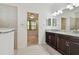 Bathroom featuring granite countertops, double sinks, tiled floor with view to bedroom at 17596 Terrazzo Way, Land O Lakes, FL 34638