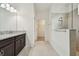 Bathroom featuring granite countertops, double sinks, tiled floor, and walk in shower at 17596 Terrazzo Way, Land O Lakes, FL 34638