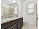 Bathroom features a granite countertop vanity, decorative mirror, and tiled floors at 17596 Terrazzo Way, Land O Lakes, FL 34638