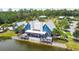 A blue house with a metal roof and a large deck overlooking a lake and surrounded by trees at 17596 Terrazzo Way, Land O Lakes, FL 34638