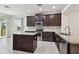 Modern kitchen features dark wood cabinetry, stainless steel appliances, granite countertops, and a functional center island at 17596 Terrazzo Way, Land O Lakes, FL 34638