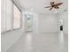 Bright living room with tile flooring, a decorative ceiling fan, and views to the front door at 17596 Terrazzo Way, Land O Lakes, FL 34638