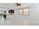 Open-concept living room with tile floors, large windows, ceiling fan, and open access to the modern kitchen at 17596 Terrazzo Way, Land O Lakes, FL 34638