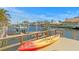 Waterfront dock with kayak, boat, and views of the canal and neighborhood homes on a sunny day at 2028 Illinois Ne Ave, St Petersburg, FL 33703