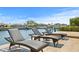 Wicker lounge chairs and side tables on a tan tiled deck with water and boats in background on a sunny day at 2028 Illinois Ne Ave, St Petersburg, FL 33703