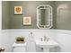 Elegant powder room with wainscoting, decorative mirror, and classic fixtures at 2028 Illinois Ne Ave, St Petersburg, FL 33703