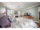 Bright bedroom featuring a fireplace, ceiling fan, and a view into the bathroom at 2086 Whitney N Pl, Clearwater, FL 33760