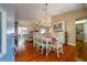 Open-concept dining area adjacent to the living room, featuring hardwood floors and elegant white dining set at 2086 Whitney N Pl, Clearwater, FL 33760