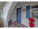 Welcoming front entrance with blue door, decorative accents, and a stone floor, offering a warm first impression at 2086 Whitney N Pl, Clearwater, FL 33760