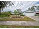 Single-story home showcasing a well-maintained lawn and mature landscaping with a flowerbed, adding curb appeal at 2086 Whitney N Pl, Clearwater, FL 33760