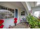 Cozy front porch area with flagstone, a small table, and chairs, perfect for relaxing outdoors at 2086 Whitney N Pl, Clearwater, FL 33760