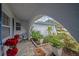 Inviting front porch with stone flooring, seating area, and views of the lush landscaping at 2086 Whitney N Pl, Clearwater, FL 33760