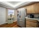 Bright kitchen with stainless steel refrigerator, wood cabinets, and hardwood floors at 2086 Whitney N Pl, Clearwater, FL 33760