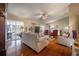 Comfortable living room features hardwood floors, a ceiling fan, and opens to a screened patio for seamless indoor-outdoor living at 2086 Whitney N Pl, Clearwater, FL 33760