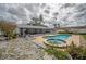 Backyard featuring a pool, spa, screened porch, and flagstone patio, offering the perfect setting for outdoor enjoyment at 2086 Whitney N Pl, Clearwater, FL 33760