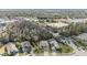 Aerial view of the home with wooded area behind the home and commercial areas in the distance at 212 Arbor Woods Cir, Oldsmar, FL 34677