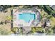 Aerial view of community pool with shaded areas, lounge chairs, and playground nearby at 212 Arbor Woods Cir, Oldsmar, FL 34677