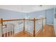 Bright hallway with wood floors, white railings, and blue walls at 212 Arbor Woods Cir, Oldsmar, FL 34677