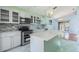 Open kitchen with stainless steel appliances, white cabinets, and a marble-top island at 212 Arbor Woods Cir, Oldsmar, FL 34677