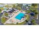 Aerial view of community pool with lounge chairs, tiki huts and sunbathers at 217 S Mcmullen Booth Rd # 179, Clearwater, FL 33759