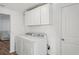 A utility laundry room features a washer and dryer, storage cabinets, and neutral walls at 2195 Glen Dr, Safety Harbor, FL 34695