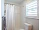 Bright bathroom features white tile, window shutters, and a shower with a white curtain at 230 S Julia Cir, St Pete Beach, FL 33706