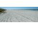 Expansive sandy beach with gentle waves meeting the shore at 230 S Julia Cir, St Pete Beach, FL 33706