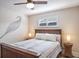 Cozy bedroom with a wooden bed frame, decorative wall art, and a ceiling fan at 230 Julia S Cir, St Pete Beach, FL 33706