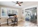 Bright office with a ceiling fan, desk, and sliding doors at 230 Julia S Cir, St Pete Beach, FL 33706