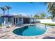 Outdoor pool with surrounding palm trees, backyard, patio, and two white chairs at 230 S Julia Cir, St Pete Beach, FL 33706