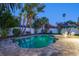 Backyard pool with brick paver deck surrounded by tropical landscaping and a privacy fence at 230 Julia S Cir, St Pete Beach, FL 33706