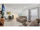 Modern living room featuring comfortable seating, white floors, and ample natural light through shuttered windows at 2419 Palmwood Dr, Holiday, FL 34690