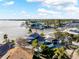 Stunning aerial view of waterfront home showcasing dock, lush landscaping, and serene water access at 2630 W Bay Isle Se Dr, St Petersburg, FL 33705