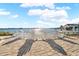 Charming backyard with waterfront views and multiple white Adirondack chairs on brick patio for outdoor relaxation at 2630 W Bay Isle Se Dr, St Petersburg, FL 33705