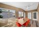 Bright dining room featuring wood-look floors, wainscotting, and a modern dining set with red chairs and a ceiling fan at 2905 Bay St, Sarasota, FL 34237