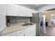 Bright kitchen with stainless steel refrigerator, granite countertops, and mosaic tile backsplash at 2905 Bay St, Sarasota, FL 34237