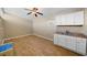 Room with ceiling fan features a kitchenette with white cabinets and mosaic backsplash at 2905 Bay St, Sarasota, FL 34237