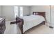 Bedroom featuring tile floors, a wood sleigh bed, a nightstand, with natural light from nearby windows at 3939 Rudder Way, New Port Richey, FL 34652