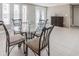 Dining area featuring tile flooring, glass table with modern chairs, and natural light from nearby windows at 3939 Rudder Way, New Port Richey, FL 34652