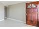 Inviting entryway with a solid wood door, neutral paint, and sleek tile flooring at 3939 Rudder Way, New Port Richey, FL 34652