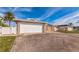 Charming single-story home featuring a two-car garage, stone accents, and a lush palm tree in the front yard at 3939 Rudder Way, New Port Richey, FL 34652