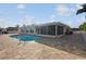 Rear exterior view of house featuring a screen lanai, paved patio, and a sparkling in-ground swimming pool at 3939 Rudder Way, New Port Richey, FL 34652