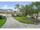 Beautiful home exterior with lush green lawn, driveway and mature shade tree at 4307 Woodmans Chart # 132, Sarasota, FL 34235