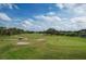 Aerial view of golf course with sand traps and players enjoying a sunny day of golf at 4307 Woodmans Chart # 132, Sarasota, FL 34235