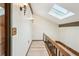 Bright hallway with wood floors, natural light from a skylight, and wooden handrail at 4307 Woodmans Chart # 132, Sarasota, FL 34235