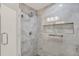 Modern bathroom showcases a glass enclosed shower with gray marble-style tile and a built-in shelf at 4309 Deepwater Ln, Tampa, FL 33615