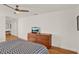 A bedroom featuring wood floors, a ceiling fan, and a modern dresser with a television at 4309 Deepwater Ln, Tampa, FL 33615